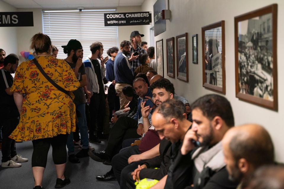 People overflow into a hallway to listen to public comment before a vote about banning the LGBTQ Pride flag on government buildings and city property, including other flags representing racial and political issues, during a city council meeting at Hamtramck City Hall on Tuesday, June 13, 2023.