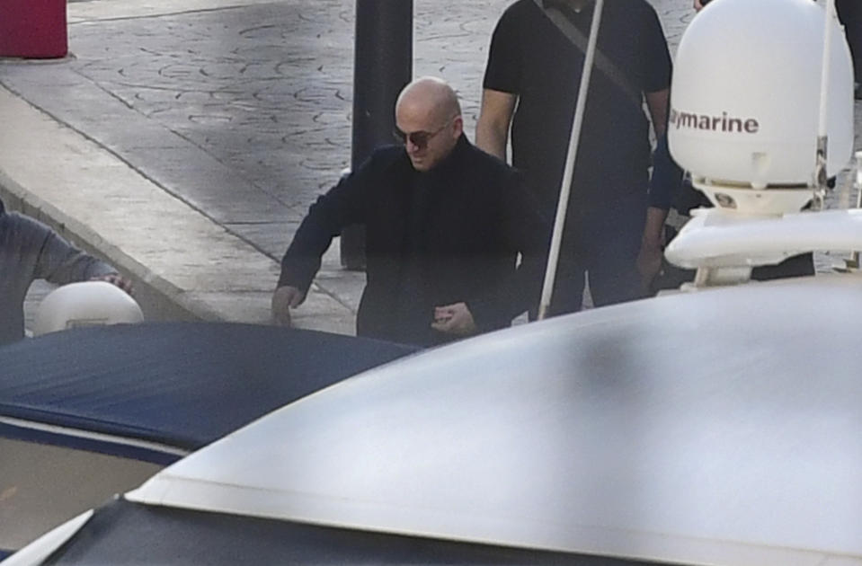 Maltese businessman Yorgen Fenech is accompanied by police during a search of his yacht at the dock of Portomaso, Malta, Friday, Nov. 22, 2019. Fenech was arrested Wednesday, then released on police bail late Thursday as investigators try to find a mastermind of the 2017 murder of investigative reporter Daphne Caruana Galizia on the small island nation. (AP Photo/stringer)