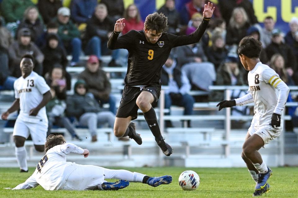 DeWitt's Brayden Powers jumps over an Eastern defender during the first half on Thursday, Oct. 20, 2022, at DeWitt High School.