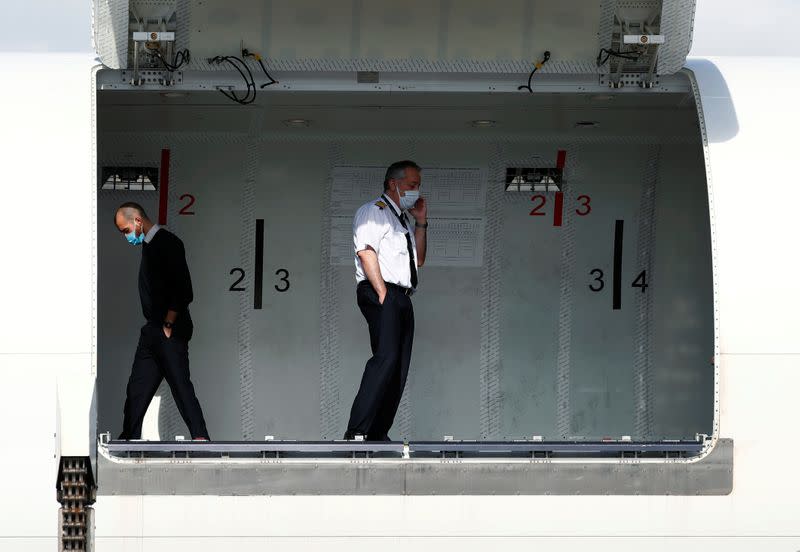 Pilots wearing protective masks are seen in a cargo aircraft at Liege airport