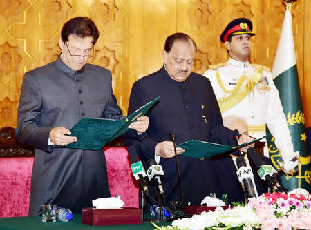 Cricketer-turned-politician Imran Khan (L) takes the oath of the Prime Minister from President Mamnoon Hussain at the Presid House in Islamabad, Pakistan August 18, 2018. Press Information Department(PID) Handout via REUTERS