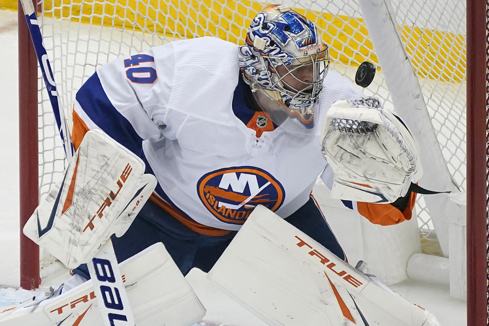 A shot by Pittsburgh Penguins' Bryan Rust gets over the glove hand of New York Islanders goaltender Semyon Varlamov for a goal during the first period in Game 2 of an NHL hockey Stanley Cup first-round playoff series in Pittsburgh, Tuesday, May 18, 2021. (AP Photo/Gene J. Puskar)