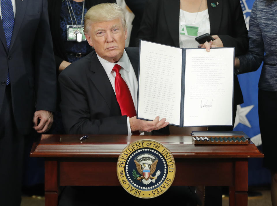 President Donald Trump holds up an executive order for border security and immigration enforcement improvements after signing the order during a visit to the Homeland Security Department headquarters in Washington, Wednesday, Jan. 25, 2017. (AP Photo/Pablo Martinez Monsivais)