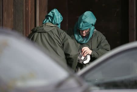 Experts wearing protective suits are seen at a duck farm in Nafferton, northern England November 17, 2014. REUTERS/Phil Noble