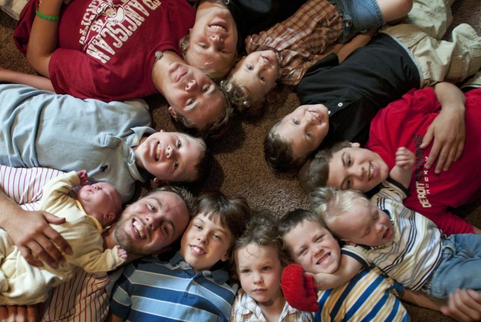 The Schwandt brothers, all 12 of them before the birth of brother Francisco, pose for a photo in their Rockford home . Clockwise from bottom left, Tyler,   holding Tucker,   Vinny,   Drew,   Zach,   Charlie,   Calvin,   Brandon,   Luke,   Gabe,   Wesley,   and Tommy .