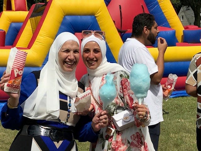 Participants at the Eid Festival at the Teaneck Armory enjoy cotton candy and popcorn