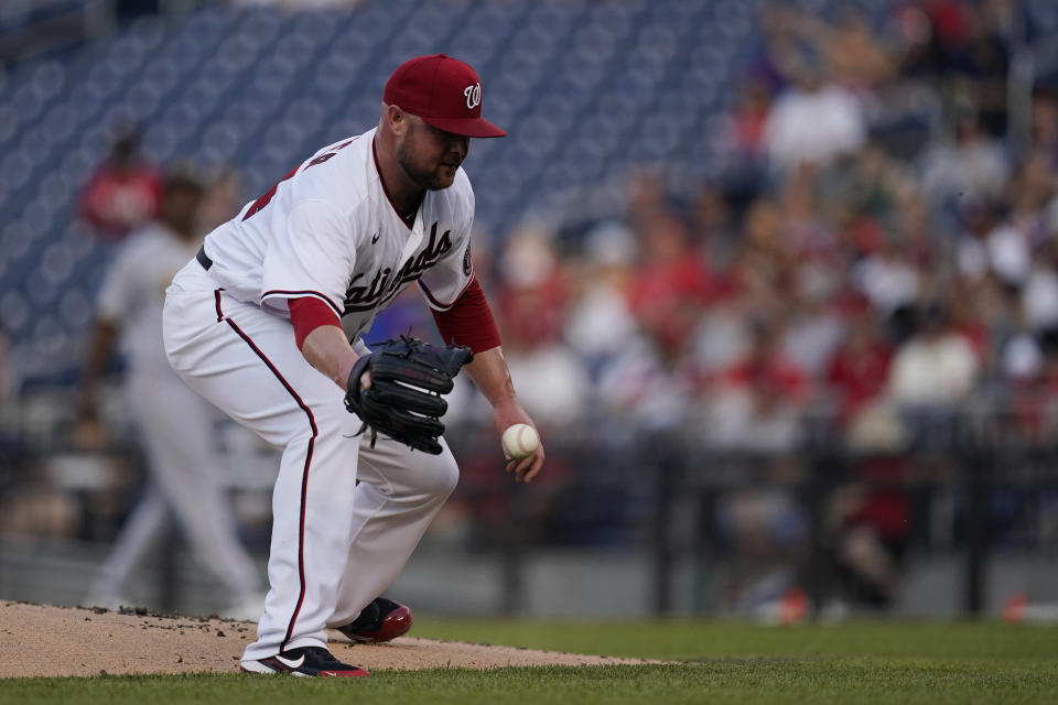 Washington Nationals starting pitcher Jon Lester fields a ball hit by Pittsburgh Pirates' Erik Gonzalez (2) during the first inning of a baseball game, Monday, June 14, 2021, in Washington. Lester made the out at first. (AP Photo/Carolyn Kaster)