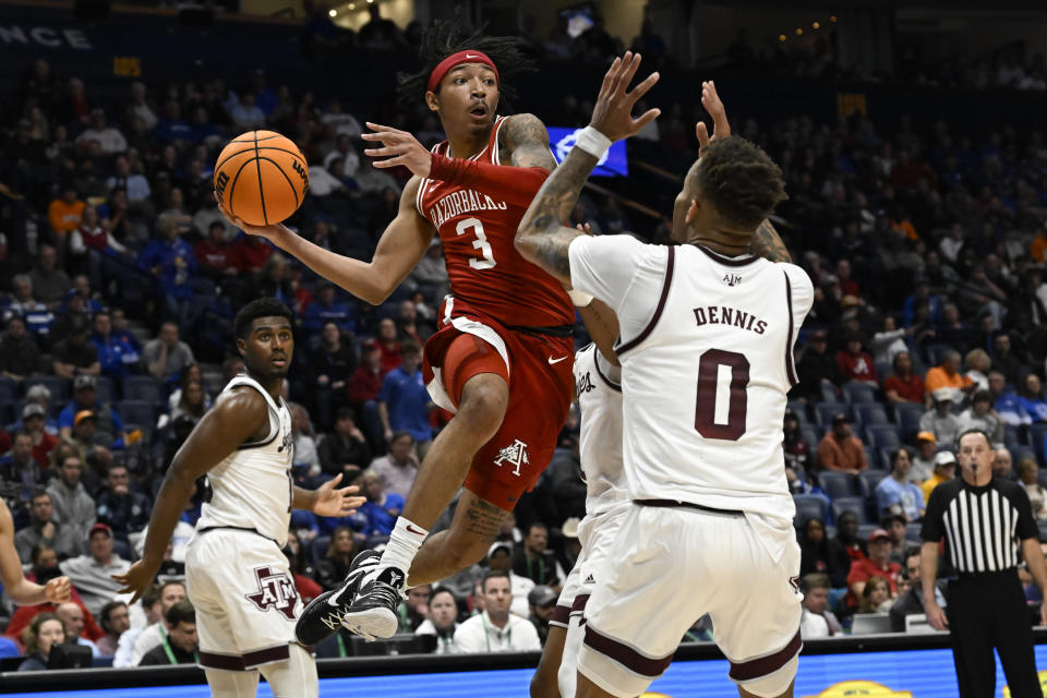 Arkansas guard Nick Smith Jr. (3) looks to pass as Texas A&M guard Dexter Dennis (0) defends during the first half of an NCAA college basketball game in the quarterfinals of the Southeastern Conference Tournament, Friday, March 10, 2023, in Nashville, Tenn.(AP Photo/John Amis)