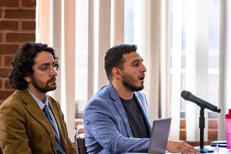 Miguel Sanchez (right) testifies during a Providence City Plan Commission meeting on May 21 about a zoning ordinance to allow retail marijuana sales in the city. City council policy coordinator Miguel Youngs sits to the left.