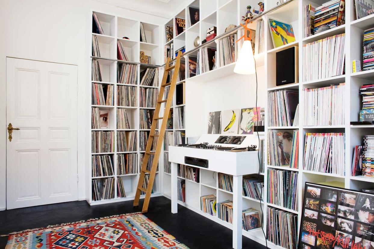Music room with shelving for vinyl records storage and a turntable in the middle.