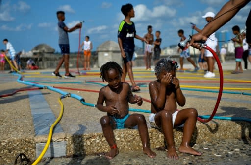 Children play with hoses as part of an art installation during the 13th Havana Biennial