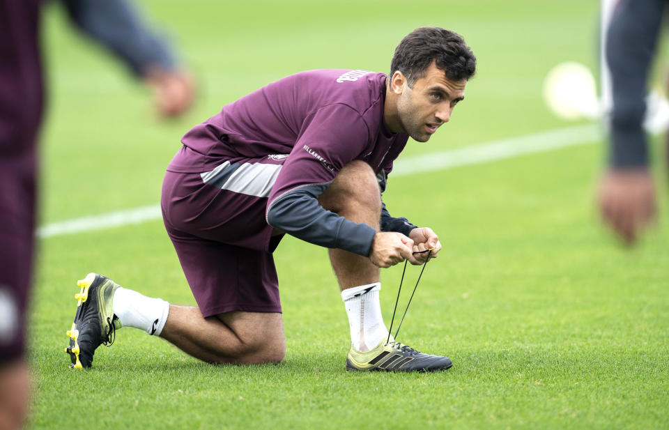 In this photo released by Villarreal Club de Futbol on Tuesday, Oct. 15, 2019, Giuseppe Rossi laces up his sneakers during a training with Spanish club Villarreal, Spain. The 32-year old Rossi, the American-born striker who played for the Italian national team before a series of injuries slowed his career, is back at Villarreal, the Spanish club where he thrived in his prime. (Villareal F.C via AP)
