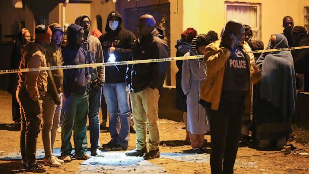 PHOTO: People, including family members, wait for news outside a township pub in South Africa's southern city of East London on June 26, 2022, after 20 teenagers died. (AFP via Getty Images)