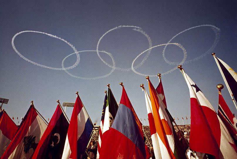 Flags of several nations and the Olympic rings in the sky are seen at the Olympic Stadium in Tokyo, Japan on 10 October 1964.