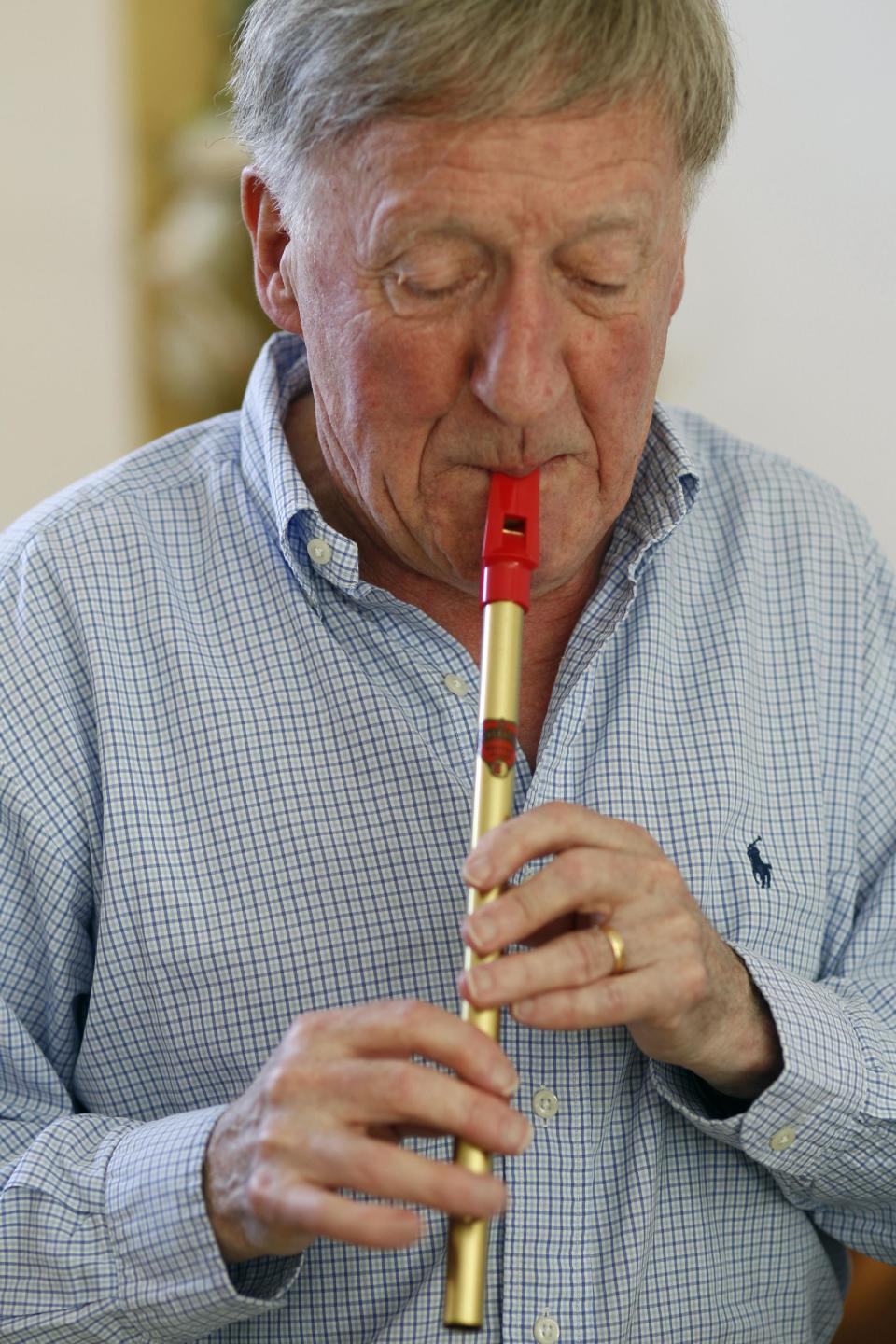 In this April 2, 2012 photo, Irish musician Paddy Moloney of the Chieftains, plays a tin whistle at his home in Naples, Fla. Moloney collaborates with musicians, Bon Iver, the Pistol Annies, the Civil Wars, the Secret Sisters, the Carolina Chocolate Drops on The Chieftains' 50th anniversary album, "Voice of Ages." (AP Photo/Lynne Sladky)