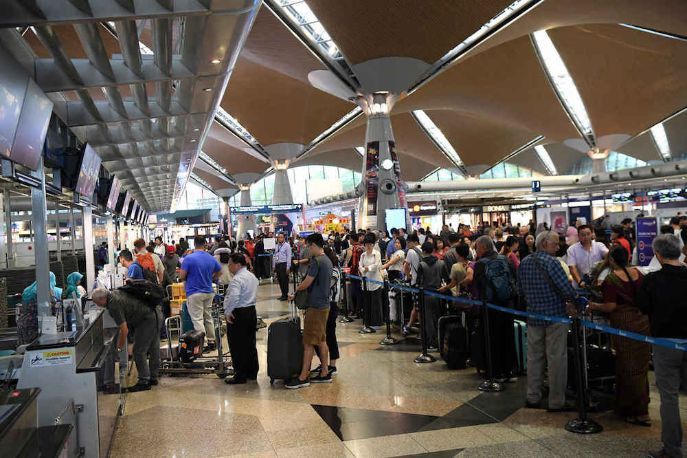 Passengers check in for their flights at KLIA in Sepang August 23, 2019. — Bernama pic