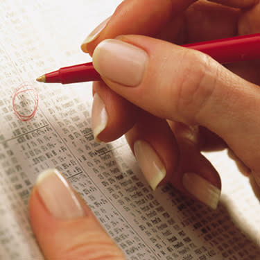 Woman-making-circling-stocks-in-newspaper-listing_web