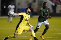 Vancouver Whitecaps FC goalkeeper Maxime Crepeau (16) throws the ball in play against Portland Timbers forward Dairon Asprilla, right, in the first half during an MLS soccer game Sunday, April 18, 2021, in Sandy, Utah. (AP Photo/Rick Bowmer)