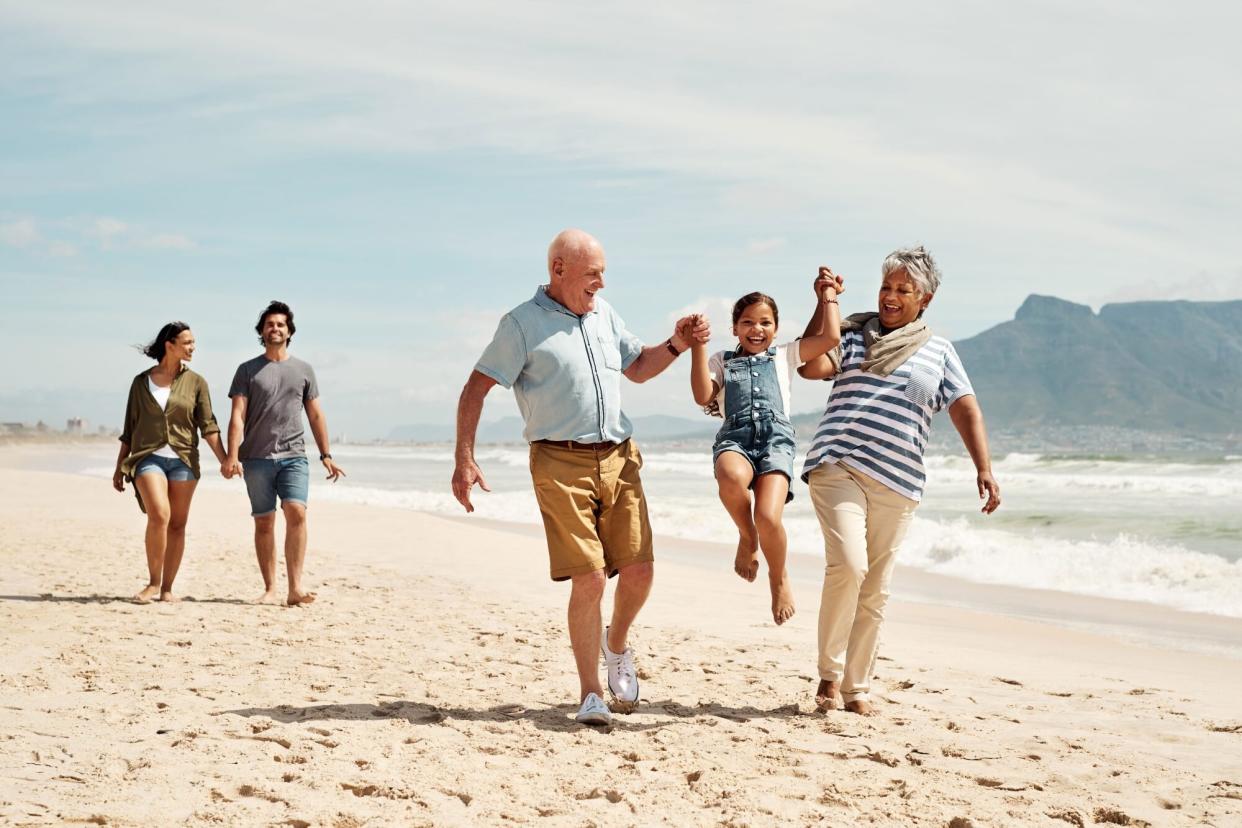 Shot of an adorable little girl having a fun day at the beach with her parents and grandparents