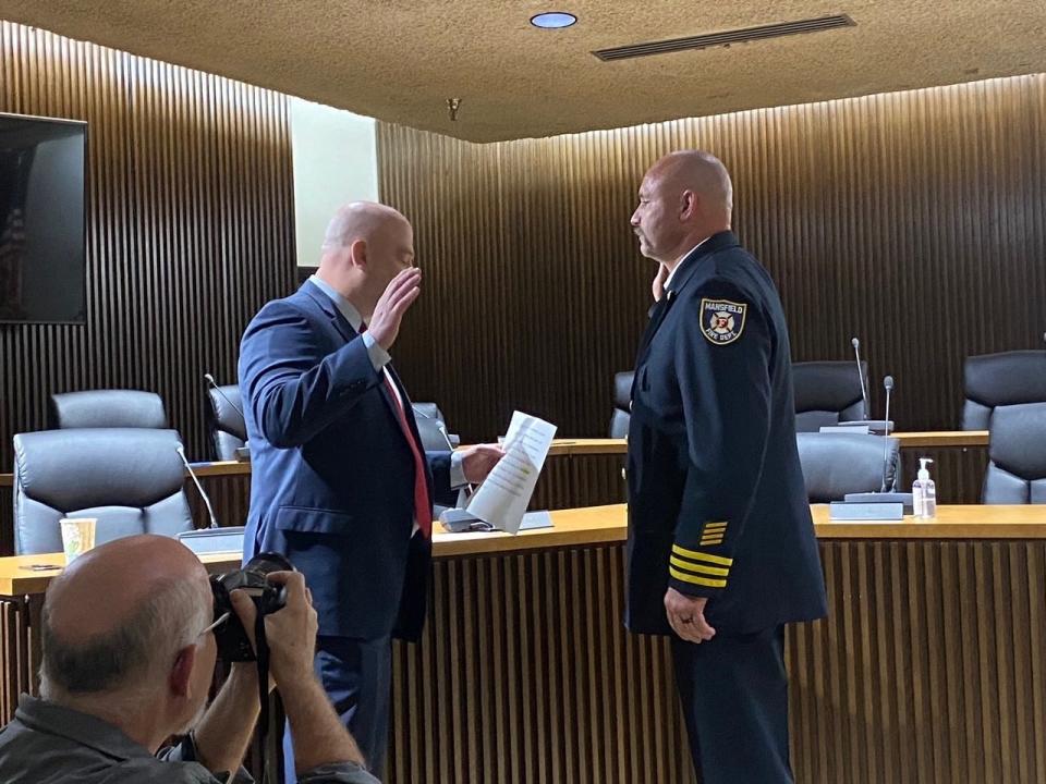 Mamsfield Safety-Service Director Keith Porch administers the oath of office to newly promoted Assistant fire Chief Robert Garn Wednesday at city Council chambers.