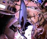 Russian astronaut Oleg Kotov holds an Olympic torch as he prepares to take it on a spacewalk outside the International Space Station in this still image taken from video courtesy of NASA TV, November 9, 2013. REUTERS/NASA TV/Handout via Reuters