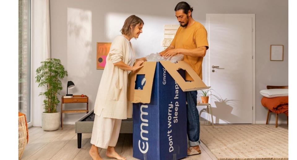 Man and woman opening Emma Sleep box with mattress inside.