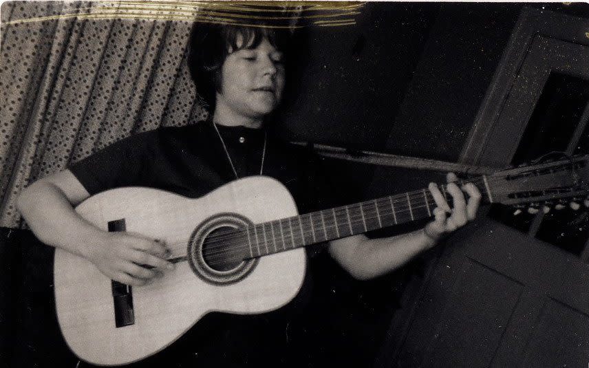 A young Janis Joplin playing the guitar