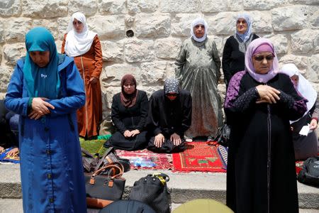 Palestinian women pray just outside Jerusalem's Old City in protest over Israel's new security measures at the entrance to the compound known to Muslims as Noble Sanctuary and to Jews as Temple Mount in Jerusalem's Old City July 20, 2017. Picture taken July 20, 2017. REUTERS/Ammar Awad