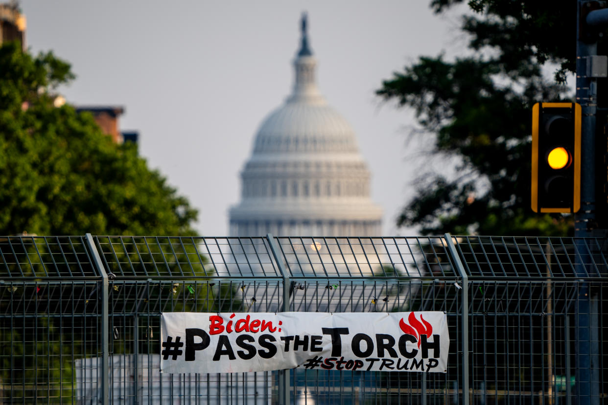 A sign encouraging Biden to exit the race is posted on the gate of an overpass near the Capitol building