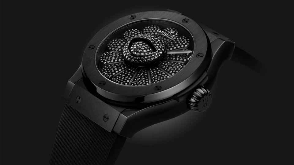 HUBLOT的All Black儼然已成為品牌招牌，為此之前他們之前找上素有「黑色詩人」之稱的日本服裝設計師山本耀司（Yohji Yamamoto）合作，推出過全黑的錶款，而這次則是將日本藝術家村上隆的彩色微笑花朵巧手修改，用黑鑽和黑陶瓷結合出創意獨具的新錶。