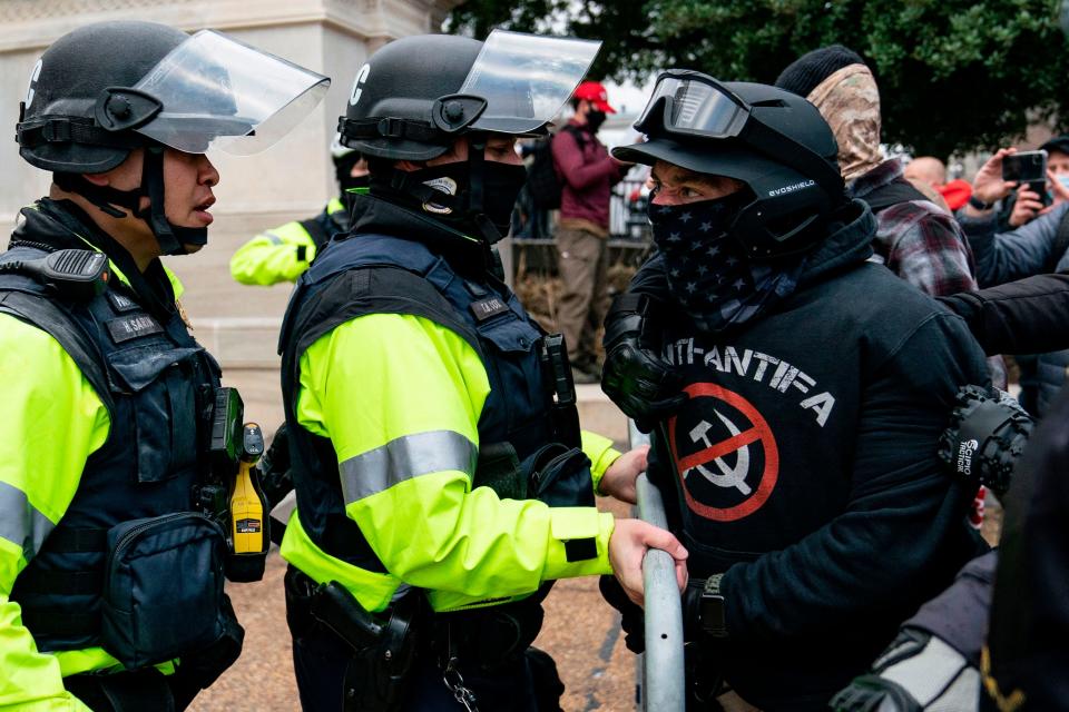 A protester, who claims to be a member of the Proud Boys, confronts police officers as supporters of President Donald Trump protest outside the U.S. Capitol on Jan. 6, 2021, in Washington, D.C.