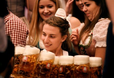 FILE PHOTO: A waitress carries mugs of beer during the opening day of the 185th Oktoberfest in Munich, Germany September 22, 2018. REUTERS/Andreas Gebert/File Photo