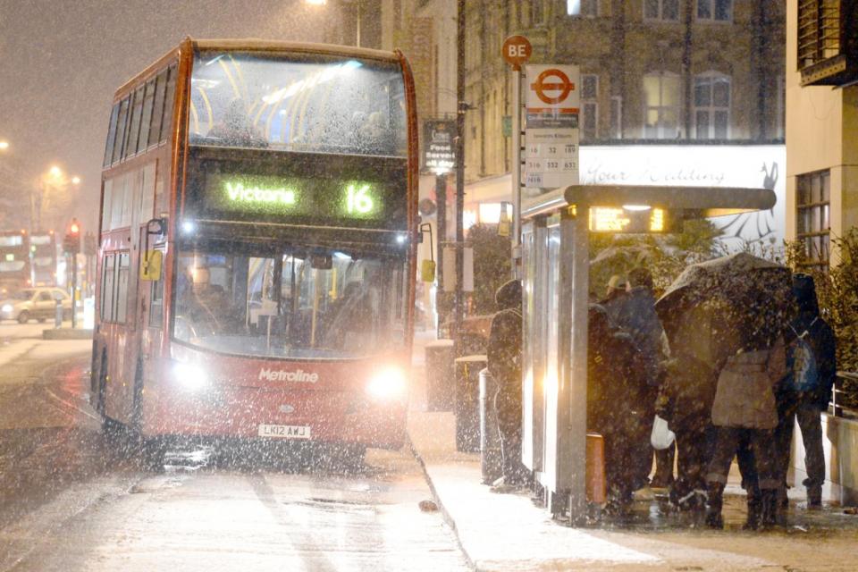 Weather: Commuters huddle under a bus shelter in Kilburn (Jeremy Selwyn)