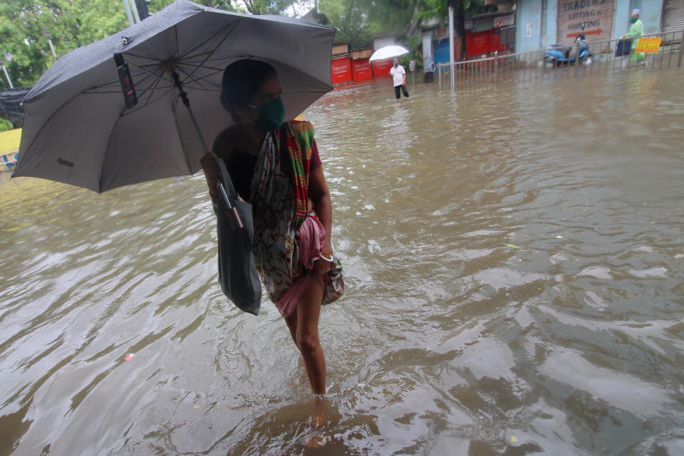 A woman holding an umbrella wades through a flooded street during heavy rains in Mumbai, on July 03, 2020. (Photo by Himanshu Bhatt/NurPhoto via Getty Images)