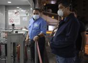 A costumer waits to enter a supermarket in Caracas, Venezuela, after Venezuelan President Nicolás Maduro today has ordered residents in the capital of Caracas and six states to stay home under a quarantine bid to control the spread of the coronavirus on Sunday, March, 15, 2020. (AP Photo/Ariana Cubillos)