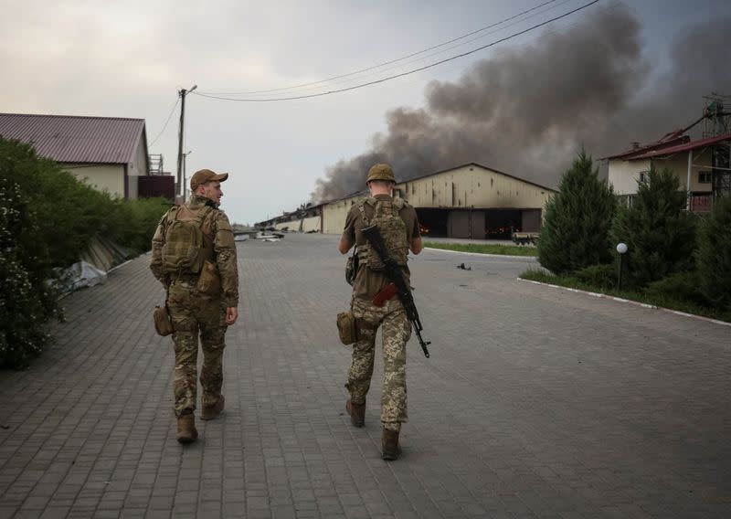 Militares ucranianos caminan mientras arden semillas en un silo de grano en la región de Donetsk