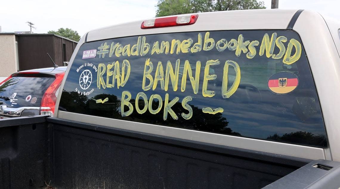 “Read banned books” is written in paint on the window of a truck in the parking lot of the Nampa School District office during a school board meeting in June.