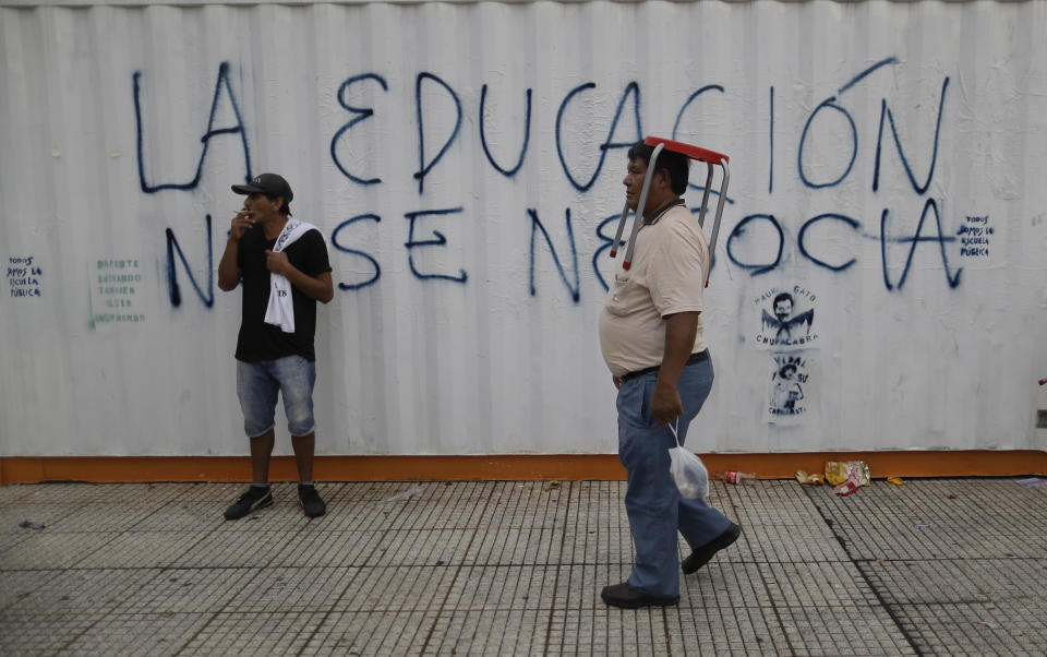 Un hombre camina frente a un grafiti durante una protesta en Buenos Aires, Argentina, el jueves 30 de marzo de 2017. Sindicatos y organizaciones sociales se manifiestan contra el presidente argentino Mauricio Macri en rechazo a las políticas económicas de su gobierno que, sostienen, perjudican a los sectores más vulnerables. (AP Foto/Natacha Pisarenko)