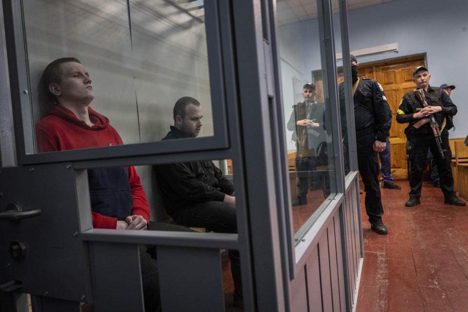 Russian soldiers Alexander Alexeevich Ivanov and Alexander Vladimirovich Bobykin, left, attend their trial hearing in Kotelva, northeastern Ukraine, Thursday, May 26, 2022. Two Russian soldiers accused of war crime in Ukraine could face up to 12 years in prison. In the second hearing of the trial held on Thursday at the Kotelevsky District Court, the prosecutors asked for both to be sentenced to 12 years of prison, while the defence attorney asked for 8 years. (AP Photo/Bernat Armangue)