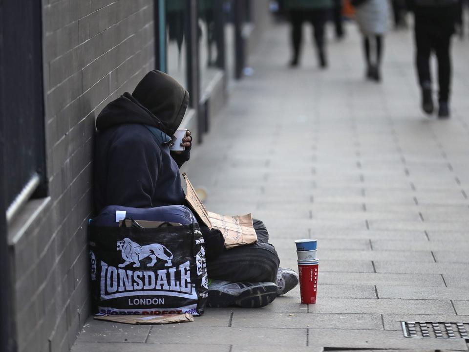 A homeless man begs for small change on the streets of Manchester: Getty