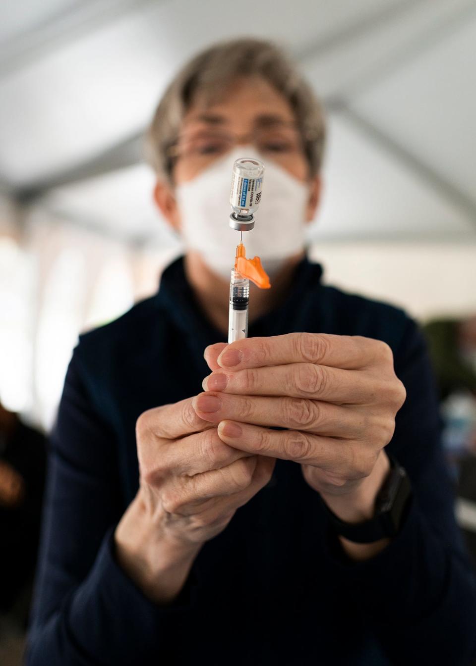 Janet Price, a retired physician, fills a needle with the Johnson & Johnson vaccine during a free clinic on May 6, 2021, in Worcester, Mass.