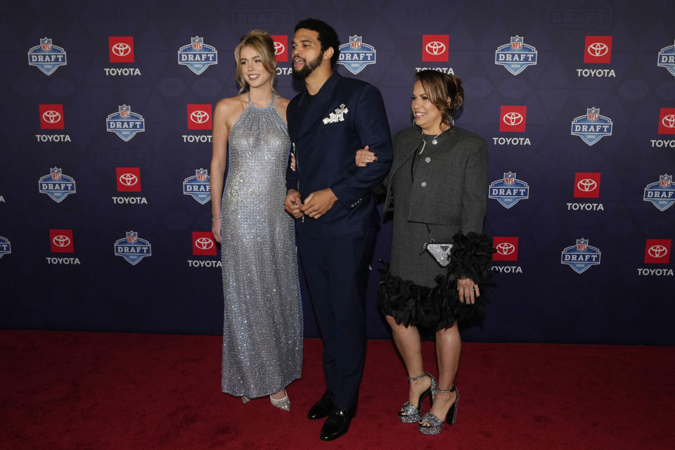 Southern California quarterback Caleb Williams, center, poses on the red carpet ahead of the first round of the NFL football draft, Thursday, April 25, 2024, in Detroit. (AP Photo/Carlos Osorio)