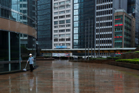 A cleaner wears a helmet at the financial Central district as Typhoon Haima approaches in Hong Kong, China, October 21, 2016 . REUTERS/Bobby Yip