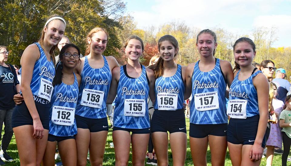 Members of Freehold Township's cross country team gather after winning the NJSIAA Group 4 title