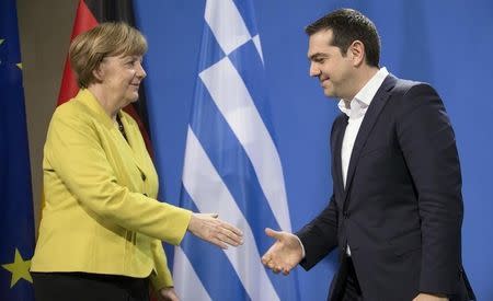 German Chancellor Angela Merkel and Greek Prime Minister Alexis Tsipras go to shake hands after addressing a news conference at the Chancellery in Berlin March 23, 2015. REUTERS/Hannibal Hanschke