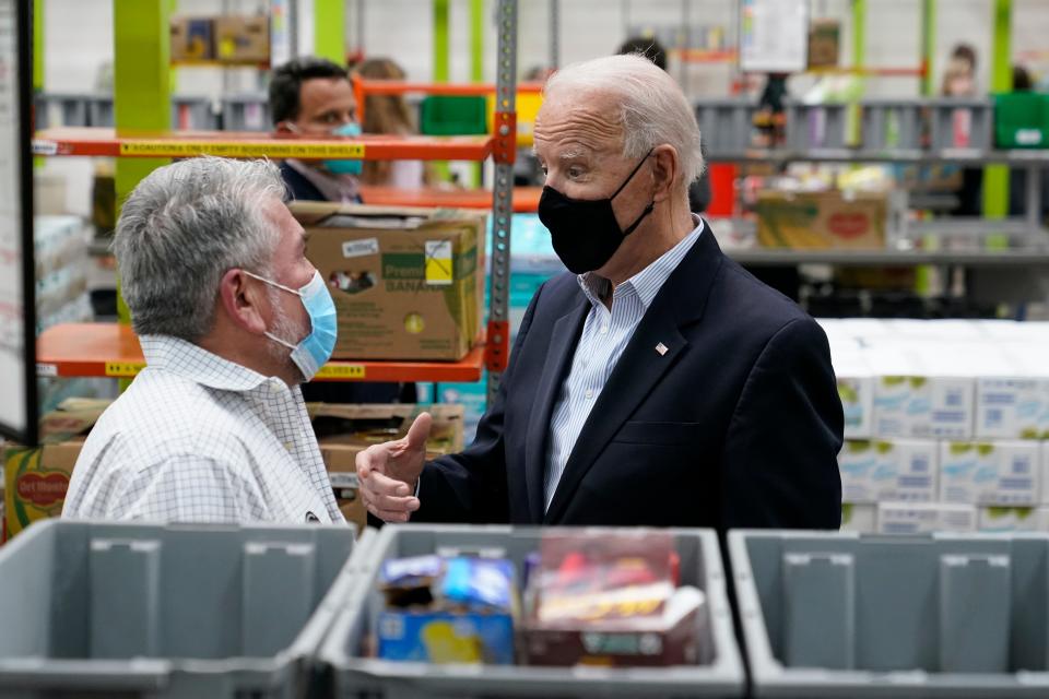 President Joe Biden talks with a volunteer at the Houston Food Bank, Friday, Feb. 26, 2021, in Houston.