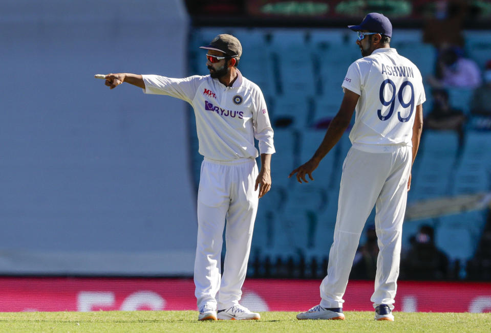 Indian captain Ajinkya Rahane, left, gestures as he talks with bowler Ravichandran Ashwin during play on day three of the third cricket test between India and Australia at the Sydney Cricket Ground, Sydney, Australia, Saturday, Jan. 9, 2021. (AP Photo/Rick Rycroft)