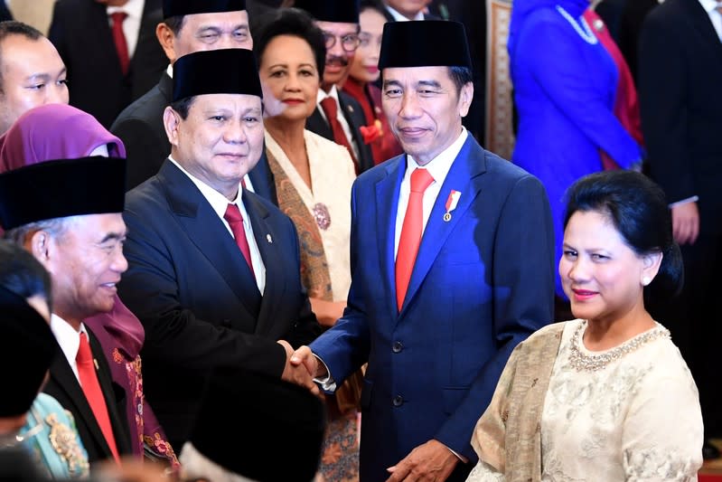 Indonesian Defense Minister Prabowo Subianto is congratulated by Indonesian President Joko Widodo, as First Lady Iriana Widodo stands next to them, after the swearing-in ceremony during the inauguration at the Presidential Palace in Jakarta