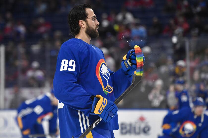 Buffalo Sabres' Alex Tuch wipes off his stick, which is covered with rainbow-colored tape, before an NHL hockey game