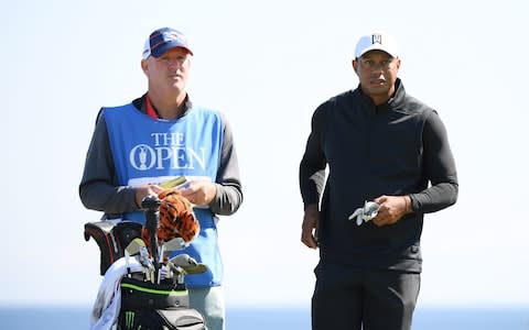 Woods (pictured with caddie Joe LaCava) was wrapped up tightly as he played 18 holes with Ryder Cup partner Patrick Reed - Credit: Getty Images